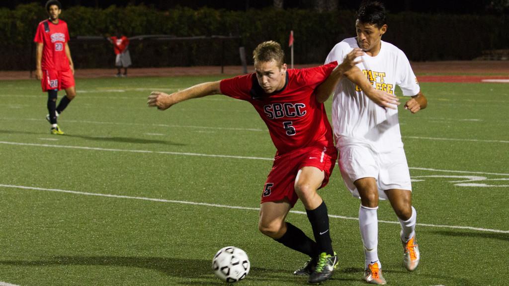 Vaqueros defender Dylan Murphy, number five, battles Taft College Cougars forward Rogelio Sustaita, number 17, at La Playa stadium in Santa Barbara, Calif. on Sept. 5, 2013. Taft College defeated The Vaqueros 1-0.