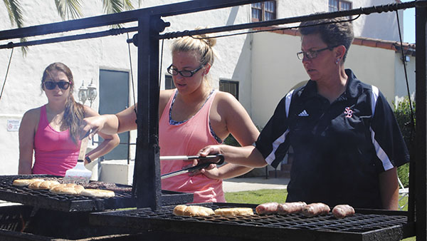 Dr. Paula Congleton flips the burgers with help from Sabine Bourret, while Sashia Pelaez looks on during a barbaque at the Veterans Memorial Building on Friday, Sept. 13, 2013, in Santa Barbara, Calif.