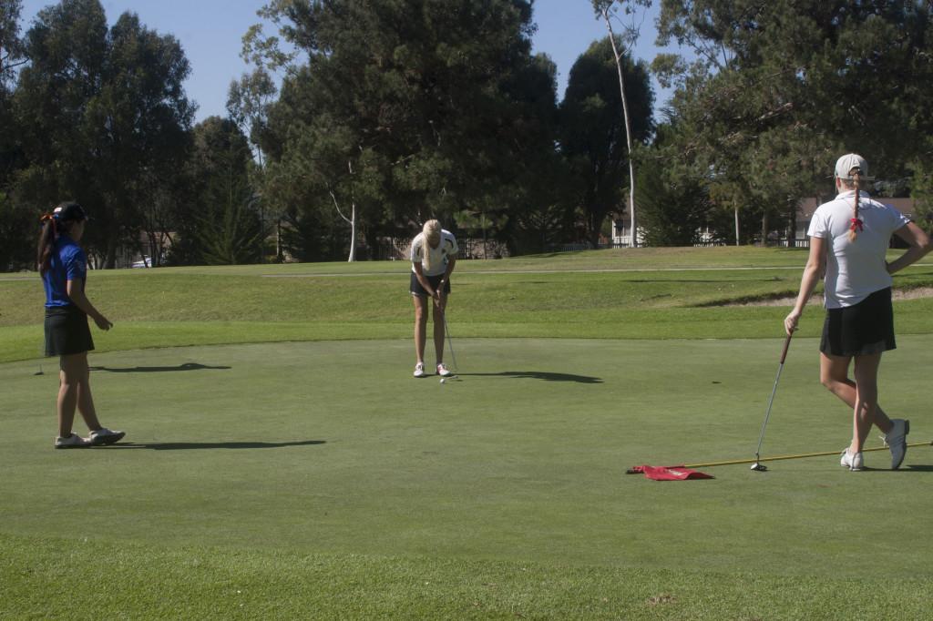 Paramee Suwantanma (left, Citrus College) and Kendall Huser (right, Bakersfield College) watch how Fanny Johansson (Santa Barbara City College) tries to make a hole at the golf invitation at the Santa Barbara Golf Club, Santa Barbara (Calif.), at oktober 14, 2013.