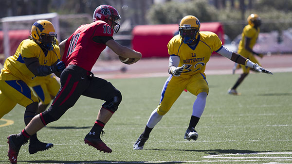 Vaqueros quarterback Joshua Martin (No.10) runs the ball passed LA Southwest linebacker Tim Lucious (No.32) to gain yards in the Oct. 5, 2013 conference matchup.