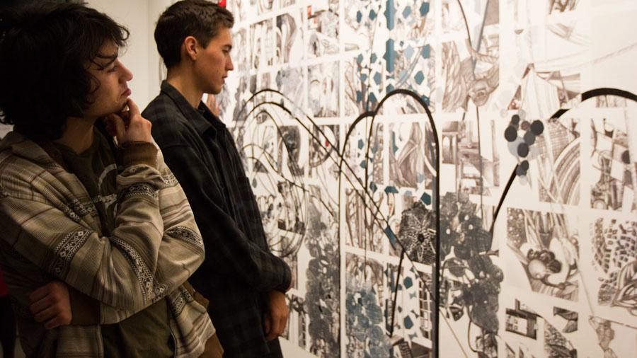 From left, City College students Rory Fearon and JJ Osterman examine the new art on Friday Jan. 31, at the Atkinson Gallery. “I can see the beauty in chaos,” said Fearon.