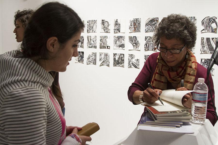 Lynne Thompson, (right) signs her book for communication major, Eranush Mkrtchyan, 21, in the Atkinson Gallery at City College. Thompson is the author of the two poetry books Start With a Small Guitar and Beg No Pardon.