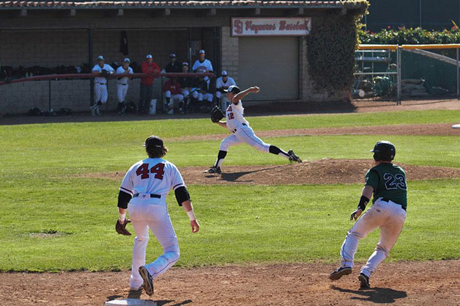 Tyler Gilbert (No. 12) pitches Thursday, March 13, at Pershing Park. RJ Hassey (No. 23) from Cuesta College takes his lead; meanwhile, first baseman, Trey Barrett (No. 44) prepares for the pitch.