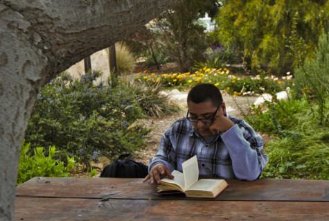 City College student, Antonio Gomez, reads the book "Killer Joe" by Tracy Letts at the Chumash Point on Friday, 25 April. "If you really wanna go to a peaceful place, this is the spot," Gomez said. Photo by Catalina Avila.