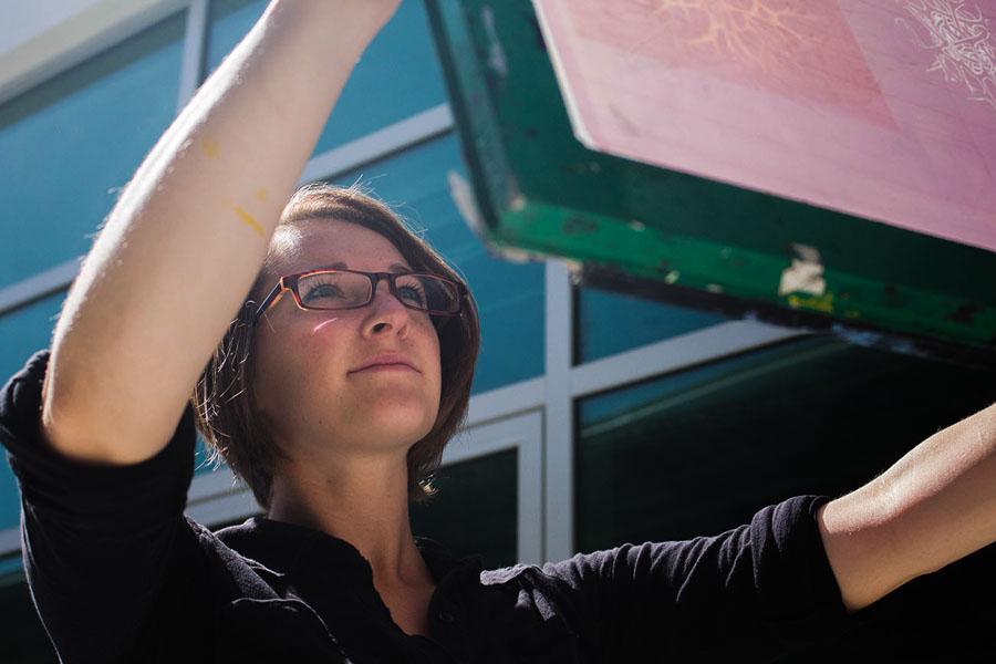 Sasha Colbert, 22, inspects an original silk screen design for damage on Wednesday, May 7, outside of the screen printing lab of the Humanities Building at City College in Santa Barbara, Calif. Colbert won three awards, including the Presidents Purchase Award, at the Annual Student Exhibition in the Atkinson Gallery for her etching entitled, Staying Late.