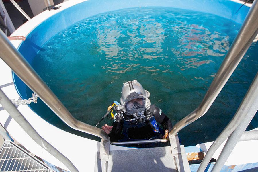 Samantha Hodges, May 2012 City College graduate, gets out of the water after trying out the new ‘Kirby Morgan 97’ helmet on Friday, Sept. 19, at the Marine Diving Technologies Building.