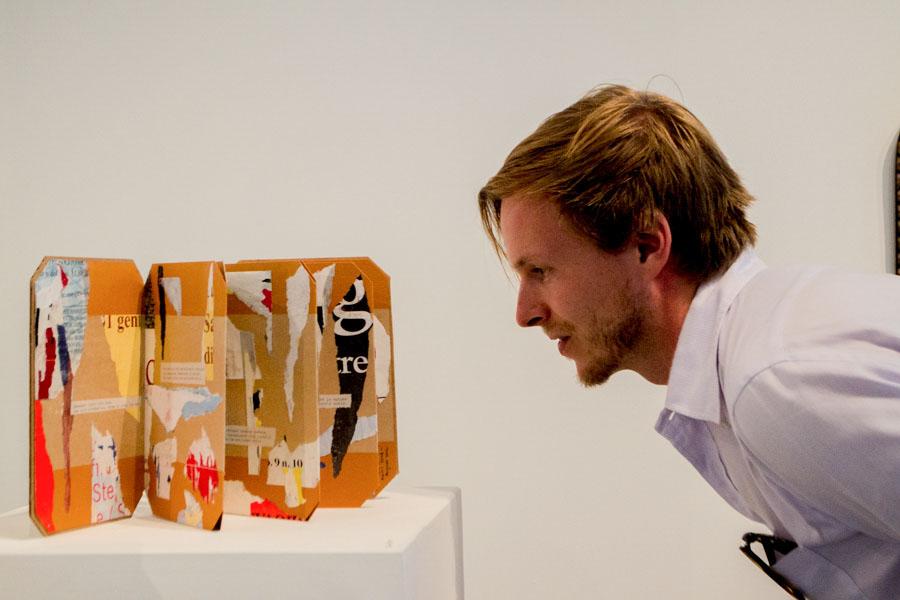 Adjunct faculty member Kevin Evans stops to contemplate the collage "After Words," at the City College Art Faculty Biennial on Friday, August 29, in the Atkinson Gallery. This piece was created in 2012 by art history professor Thomas Larson, and is on display until Sept. 26.