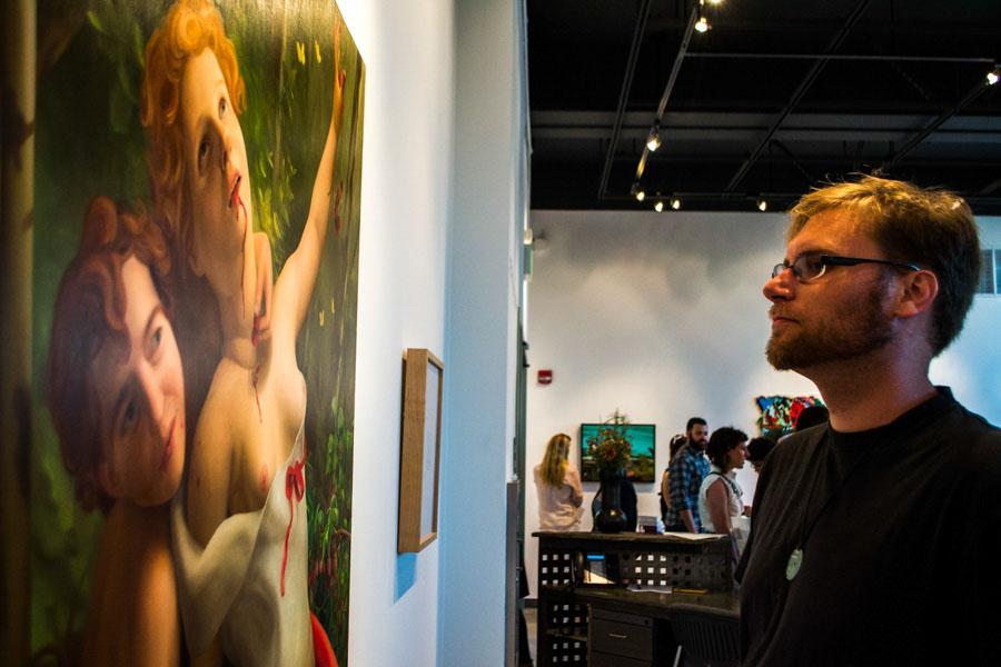City College student Byron Blanco observes Laura Krifkas oil painting, Lambs, featured in this years Art Faculty Biennial exhibit hosted by the Atkinson Gallery on Friday, August 29. The piece, priced at $800, was created this year and will be on display through Sept. 26.