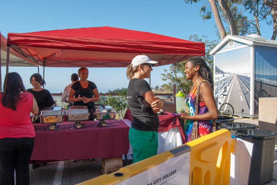 At the SBCC Commute pancake breakfast, (front left) Perrin Pellegrin, program coordinator and City College consultant, asks student Gerrie Mobley about how she commuted to school that morning, Thursday, Aug. 27, by the East Campus Bike Shop. Sustainable commuters were rewarded with a pancake breakfast, served with help from the Culinary Department.