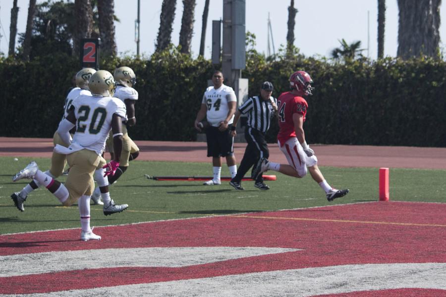 Vaqueros running back Chad Woolsey (No. 24) strides into the end zone for a touchdown with opposing team members in pursuit, bringing the score for Santa Barbara 6 to 7 over rival team LA Valley, at 1 p.m. Saturday, Oct. 17 at La Playa Stadium, Santa Barbara City College. The game ended in a 27 to 28 loss for City College to LA Valley.