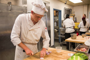 Peter Wolfgram, final year culinary arts student, demonstrates the correct way to cut vegetables to avoid injury, Thursday, Oct. 8, in Campus Center Building Room CC108 in the School of Culinary Arts in Santa Barbara.