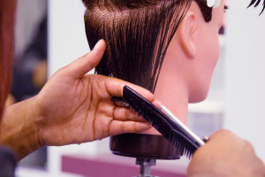 Cosmetology student Karianna Farmer does a short layered cut on her ‘Maria’ mannequin during her night class at the Cosmetology Academy, Wednesday, Nov. 4, in Goleta.