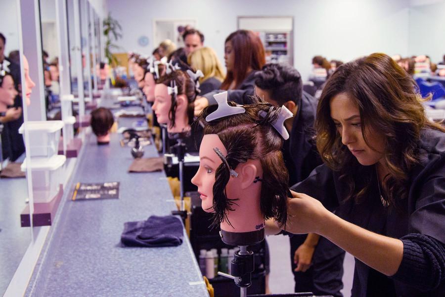 Cosmetology student Alma Rosie Ortiz does a short layered cut on her ‘Maria’ mannequin, with fellow students enrolled in the revitalized night time program, Wednesday, Nov. 4, at the Santa Barbara City College Cosmetology Academy, Goleta. The night program has been cancelled since 2009, and was revived this past September.