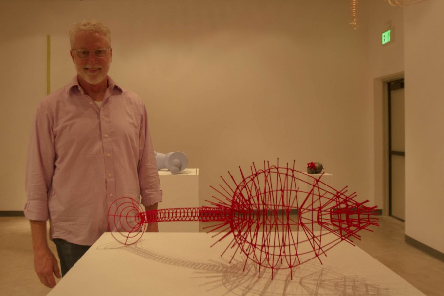 Edward Ink, 3D Design and Sculpture Professor, poses in front of one of his sculptures at his retirement open art exhibit Ed Inks Has Left the Building on Friday, Jan. 29, at the Atkinson Gallery. In honor of his retirement the reception was held in the Humanities building to display his sculptures.