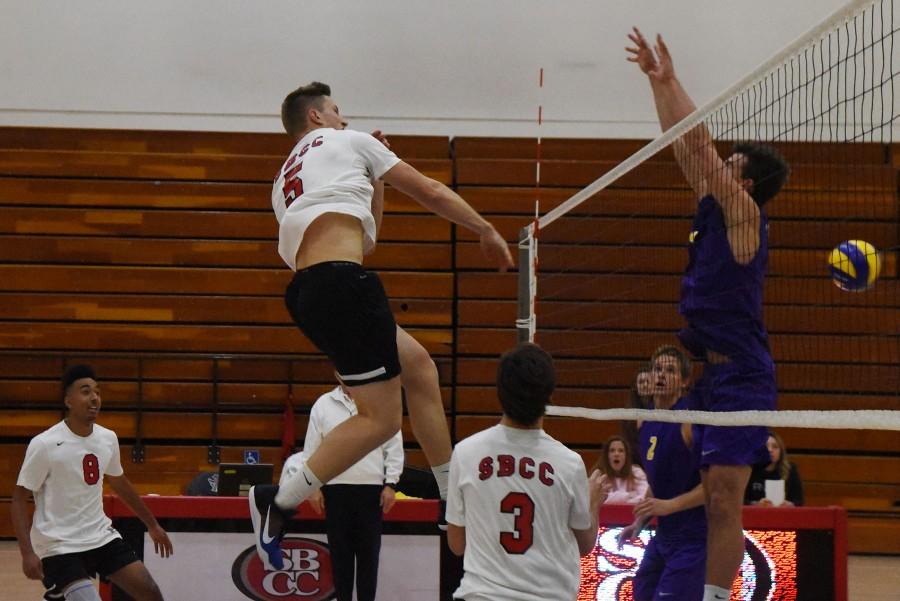 Vaquero sophomore middle-back Robert Gulvin (No. 5) spikes the ball past Cal Lutheran University defender Schaun Billing (No. 9) for a kill during the City College win on Wednesday, Feb. 3, in the Sports Pavilion. The Vaqueros won the season opener against the Kingsmen in four sets, 20-25, 25-21, 25-23 and 25-14.