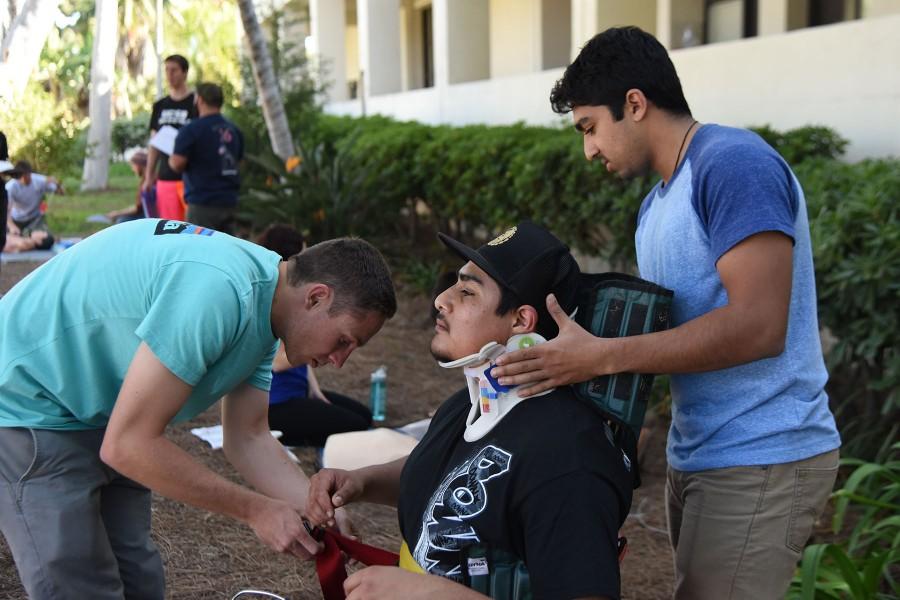 EMT students, from left, Cody Thompson, 21, Paco Pulido, 22, and Varun Battu, 20, practice putting an immobilization device on each other during their lab on Thursday, March 24, at City College. Two of the course coordinators may be stepping down after this season.