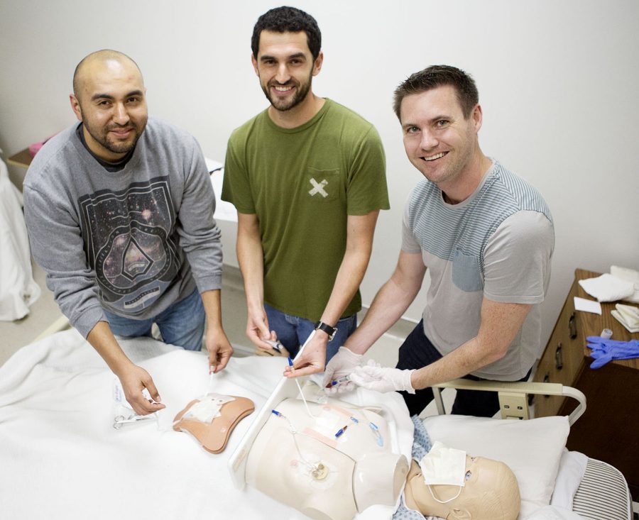 Male nursing students (From Left) Rogelio Tafoya, Tyler Lawrence, and Skyler Lyon practice changing complex abdominal wound dressings and administering medication through central lines on a practice mannequin Thursday morning, April 21, in the Health Technology Building room 277 at Santa Barbara City College, Santa Barbara. These nurses are a few of the members in the Men in Nursing club at City College.