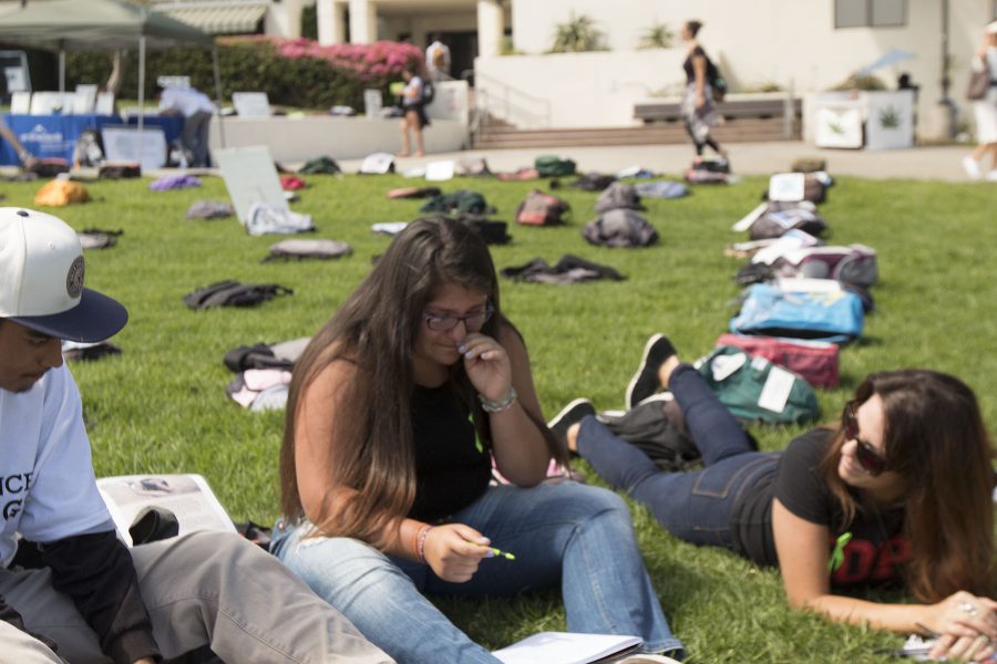 Student Yasmine Gonzalez Ibarra (center) tears up when sharing a personal experience about a family member who struggled with depression and suicide during a therapeutic writing circle on Tuesday, Sept. 20, on the City College West campus during the Send Silence Packing exhibit. This was Gonzalez Ibarra’s first time sharing this with a group.