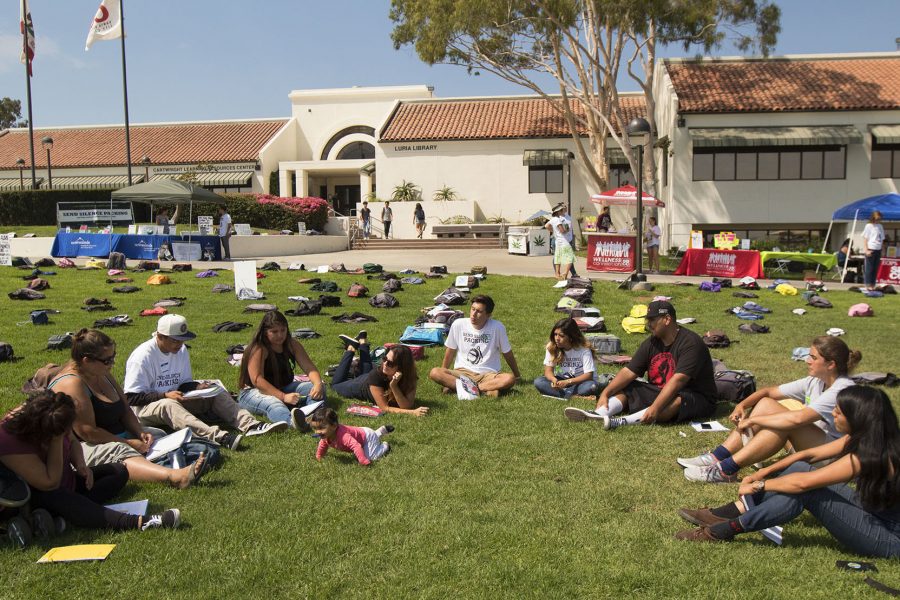 Miguel Cruz, president of the Still I Rise Writing Club (seated third from right), leads a discussion of depression and suicide during a writing circle on Tuesday, Sept. 20, during the “Send Silence Packing” event in front of the Luria Library. “I’m safe here; I feel loved,” said Cruz.