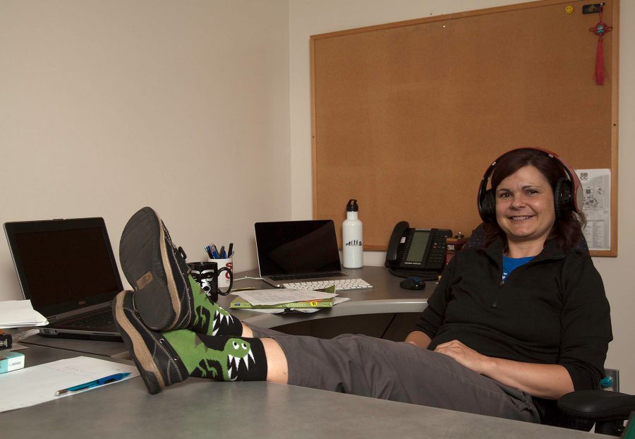 Anthropology instructor Tara Carter sits at her desk showing off her dinosaur socks on Thursday, Sept. 8, 2016, at Santa Barbara (Calif.) City College. Cater enjoys wearing different socks to the classes she teaches every day.