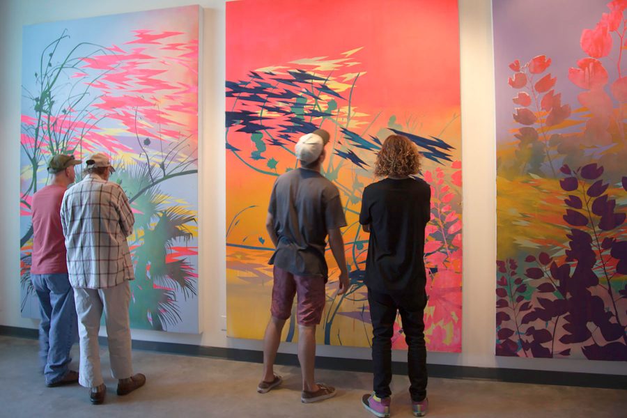 Art goers admire the work of Devon Tsuno on Friday, Sept. 16, at the Atkinson Gallery. Tsuno’s gallery consists of abstract landscape paintings that focus on Los Angeles’ bodies of water and native vs. non-native vegetation.