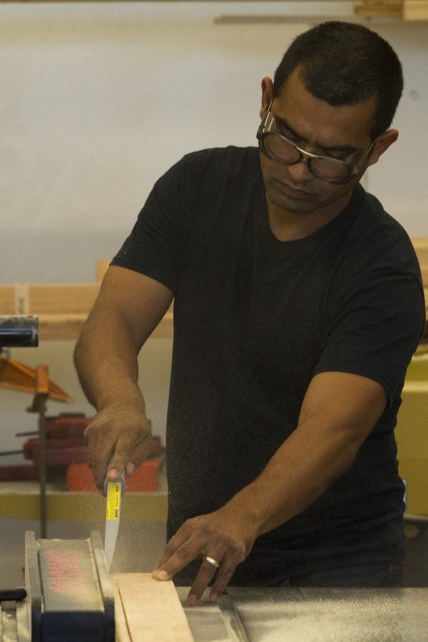 Armando Ramos demonstrates how to split wood with a table saw on Monday, Oct. 3, in his Humanities building lab at City College. Ramos is the new arts instructor who specializes in 3D sculptures made from all different types of material, including wood and cardboard.