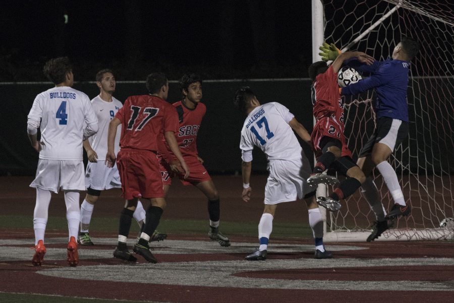 Vaquero defender Nicolas Genthon (No. 21) gets tangled up with Bulldog goalie Migel Gomez (No. 1) while trying to score on Tuesday, Oct. 11, at La Playa Stadium. City College defeated Allan Hancock College, 2-0.