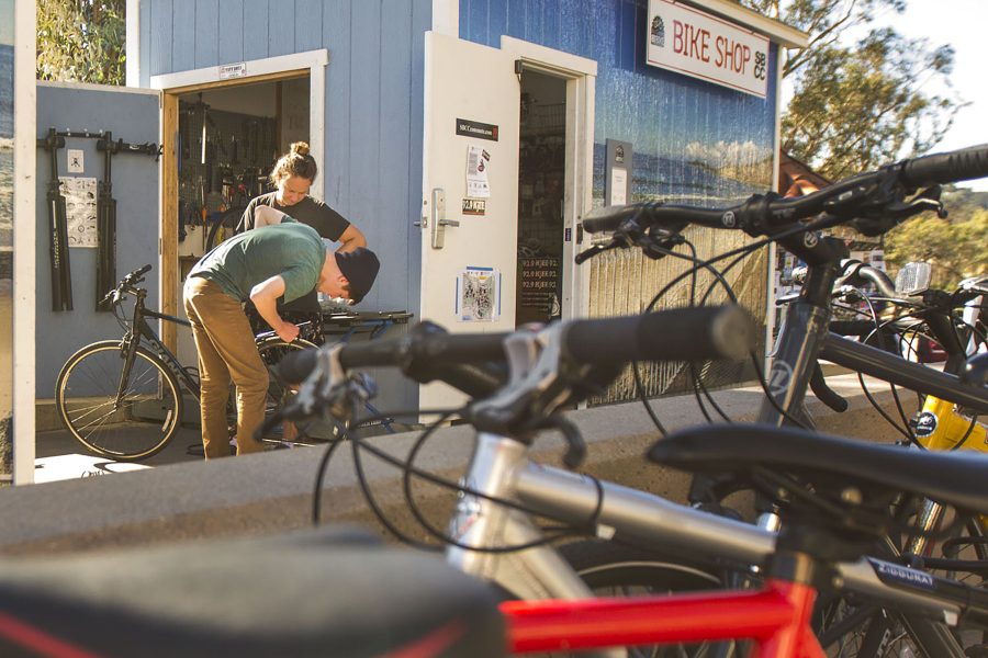 Lynneal Williams, mechanic for the Campus Bike Shop, helps mechanical engineering student Alex Reichmayr with his rear brake cables on Thursday, Nov. 10, at the City College Campus Bike Shop. The shop is a satellite location of Bici Centro, where Williams also works.