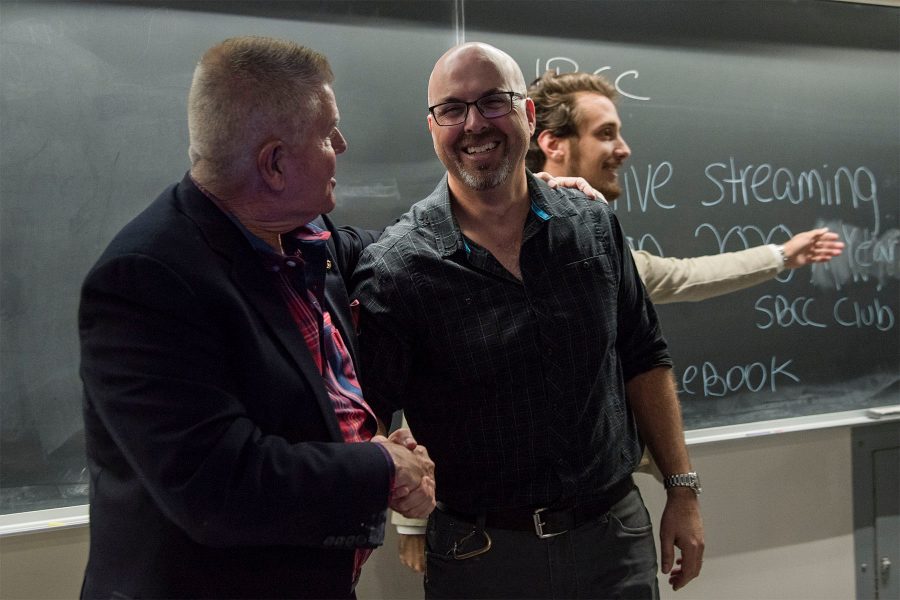 Philosophy Instructor Mark McIntire (left) shakes hands with Biological Sciences Associate Professor Adam Green after their debate about climate change put on by 2020 A Year Without War on Wednesday, Nov. 16, at City College. The two agreed on several points regarding climate change but differed on how to fix the problem.