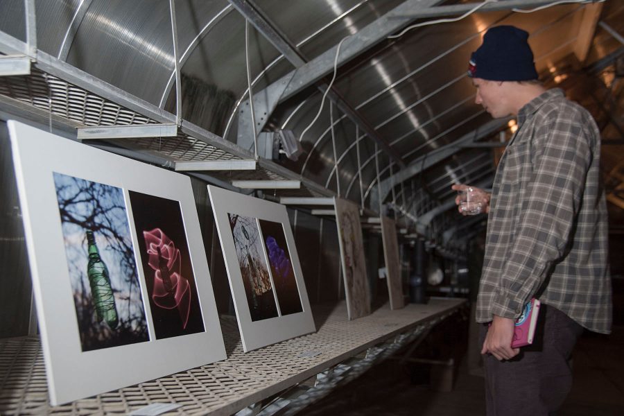 English major Cole Waldron walks through the exhibition looking at all the student works of art on Tuesday, Nov. 29, City College East Campus green house. The student art exhibition was called "Garden Observations" and had various student art works on display.