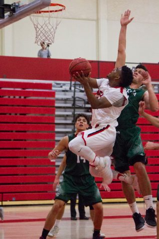City College Vaquero Drayton Howell (No. 12) attempts to regain the lead in the first half of the game against the Cuesta Cougars on Saturday, Feb. 4 in the Sports Pavilion. The game went into double overtime.