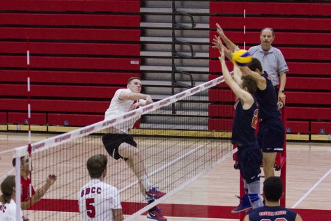 City College Vaquero Sean Reynaert (No.11) kills the ball at the beginning of set two against the defence from the Orange Coast College Pirates, Matt Ujkic (No. 7) and Bradley Hankus (No. 24) on Wednesday, Feb. 8, 2017, in the sports pavilion at Santa Barbara City College. At the beginning of set two, the Vaqueros took the lead 2-1, but the Pirates caught up and won the set, 25-12.