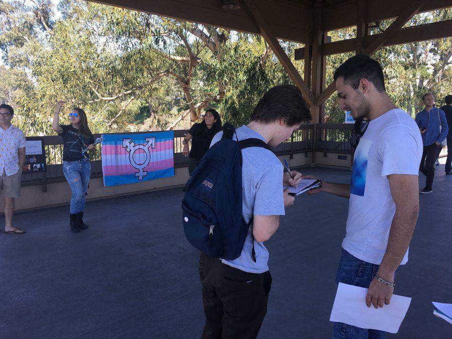 City College Student Thomas Crane signs a petition supporting gender neutral bathrooms on campus from David Panbehchi, commissioner of events for the Student Government, on Thursday, March, 16, on the bridge between East and West campus. The rally spread awareness and promoted gender inclusivity.
