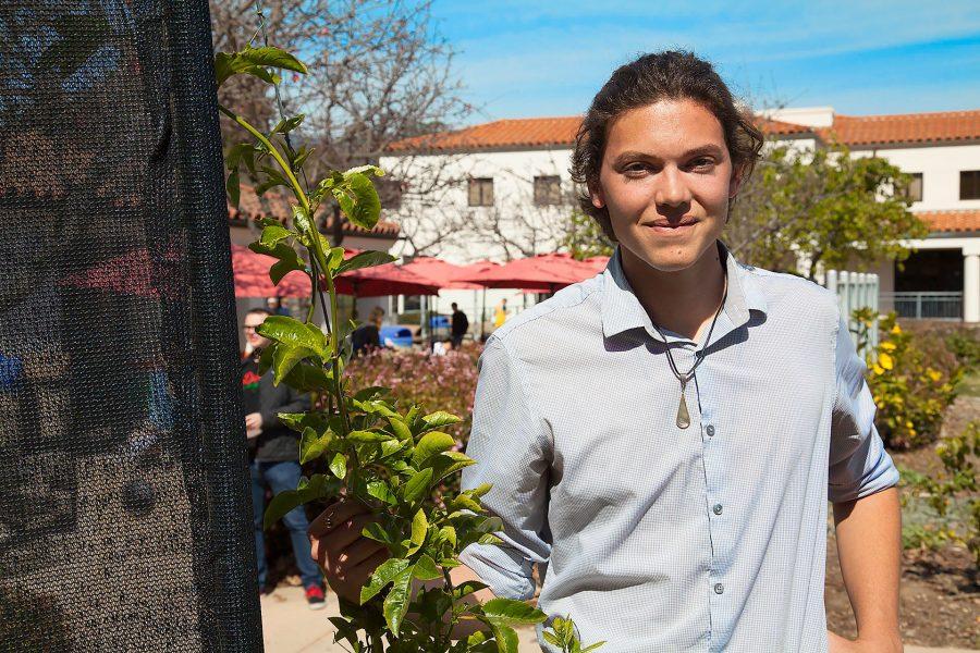 Jackson Hayes in the Permaculture Garden besides the fog catcher and his favorite plant on Tuesday, March 7, outside the West Campus Cafeteria. Hayes is the new student senate commissioner of sustainability and he has been on the student sustainability coalition for two years.