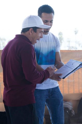 Kurt Hammer, culinary art student, signs a petition supporting gender neutral bathrooms on campus from David Panbehchi, commissioner of events for the Student Government, on Thursday, March, 16, on the bridge between East and West campus.