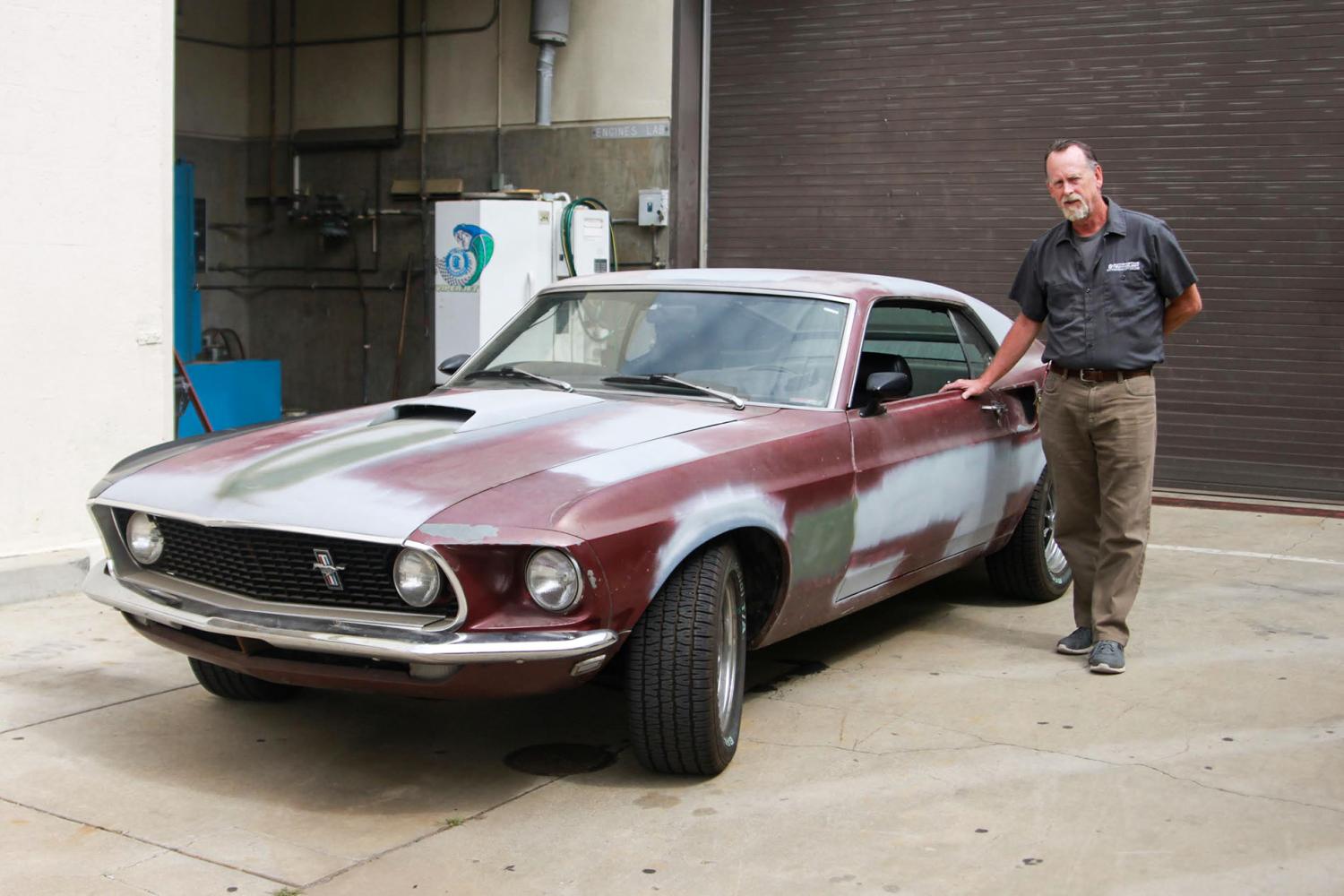 Robert Bob Stockero, automotive technology department chair, poses with his 1969 Mustang Fastback on Wednesday, April 12, at the City College auto yard. The classic car is one of the vehicles Stockero will work on restoring during his retirement.