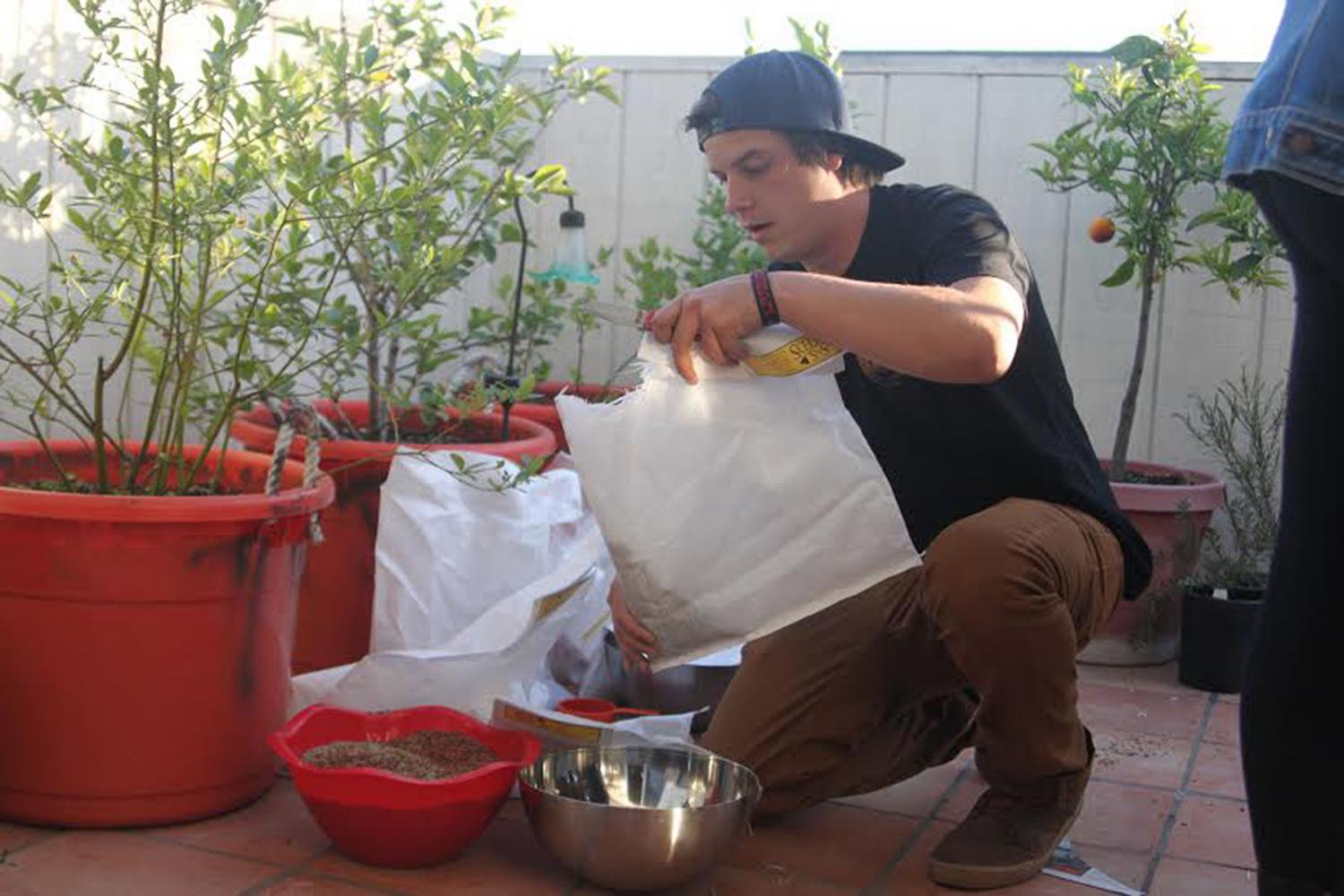 Botany Club president Tim Sisneros pours and mixes wildflower seeds into bowls on Wednesday, April 12, on Chapala street in Santa Barbara. Club members used the seeds to make seed bombs, small absorbent balls made of paper, clay or compost that contain seeds.