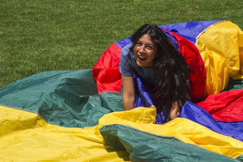 Gabriella Moreno wraps herself in a parachute during the ‘De-stress Fest’ on Wednesday, May 3, in front of the Luria Library. Students could also play with inflatable balls and hula hoops.