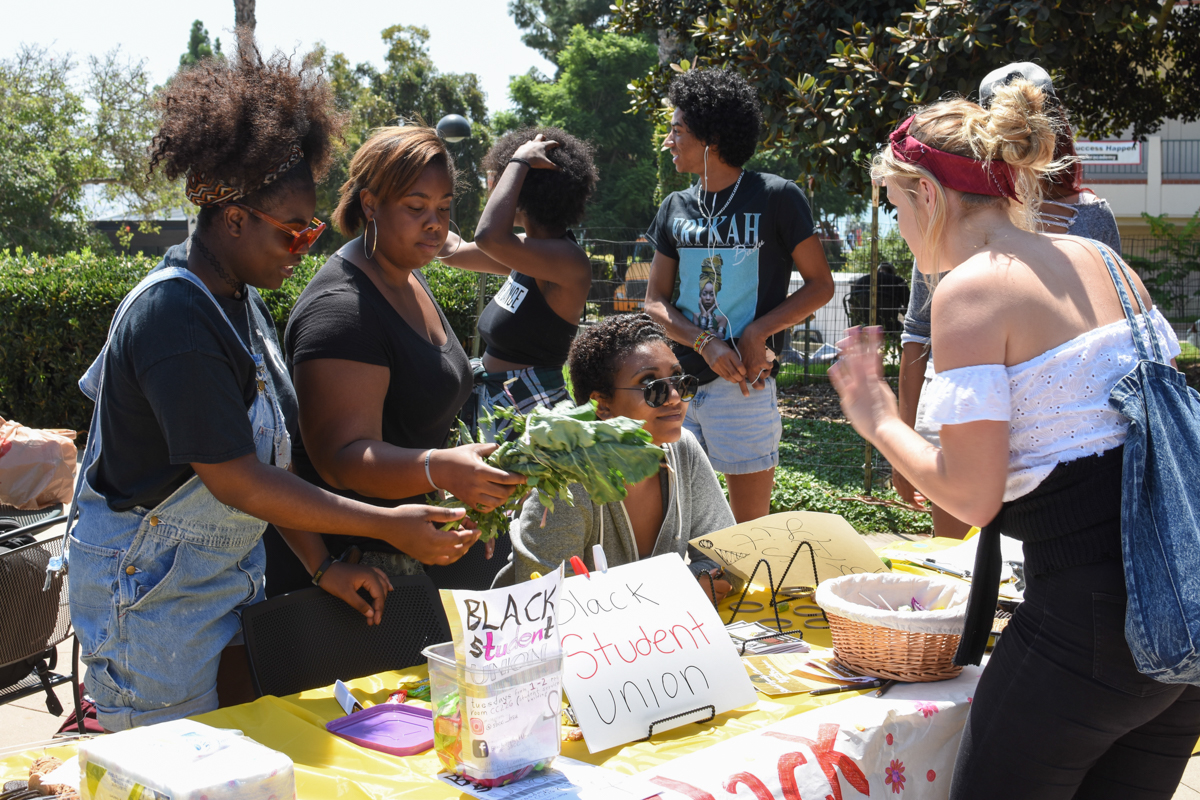 From left, Saturne Tchabong, J’Naer Bradford, and Tedenekialesh Debebe talk with a student about their club at Friendship Plaza on Sept. 6. The Black Student Union recruits currently enrolled students who are interested in Black History.