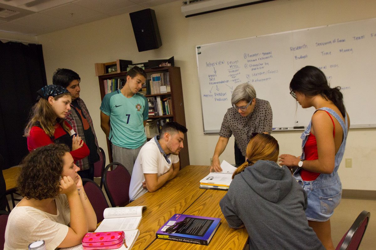 Instructor Camille Elam showing her students what a production book looks like and what it would contain Monday, Sept. 18, 2017 in Drama/Music Room 134 in City College in Santa Barbara, Calif. Students will design a whole play with images, references and sketches for a play called Lion In Winter and it is up to the students to interpret their ideas through drawings.