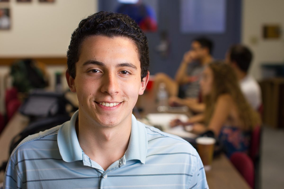 Christian Walk stands at the end of the table Sept. 25 in the student senate room in City College. Walk was the runner up for student body president for the 2017-18 school year, but is still active in student government.