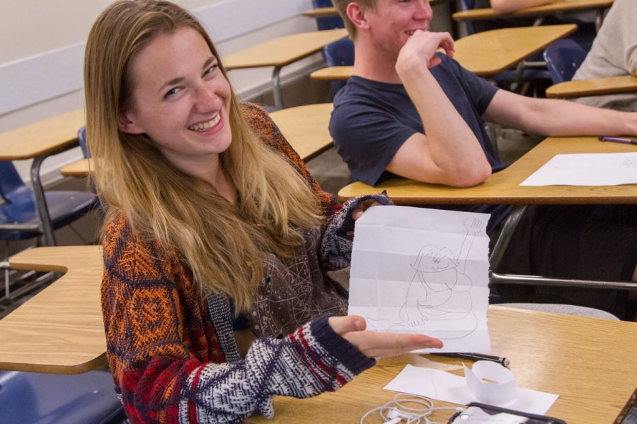 Club member Emily Hayman holds up her example of her mermaid drawing using grid lines Thursday, Oct. 18, in Interdisciplinary Center Room 106.