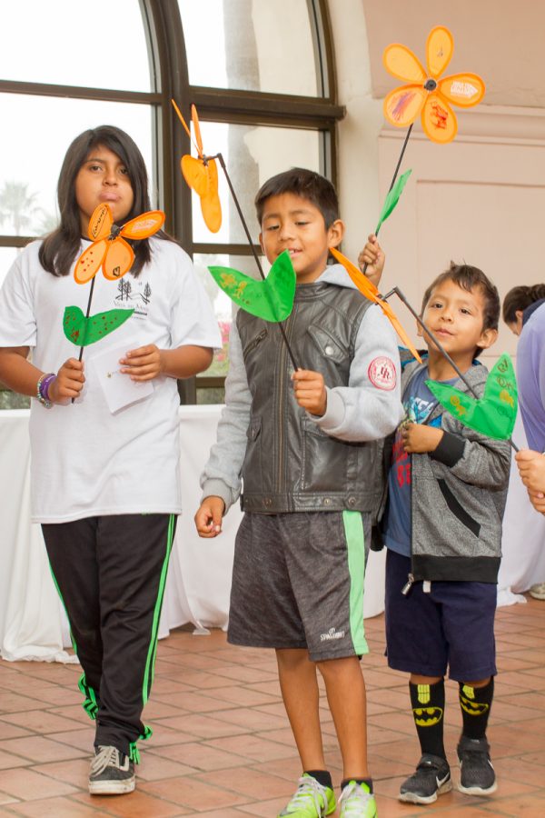 (From left) Stephany Perez, Angel Castro and Anthony Castro decorated flowers to represent their support for Alzheimer’s patients Saturday, Oct. 28, at the Fess Parker DoubleTree Resort. Different colored flowers represent a different reason for walking with orange representing support for the walk and a general want to end Alzheimer’s.