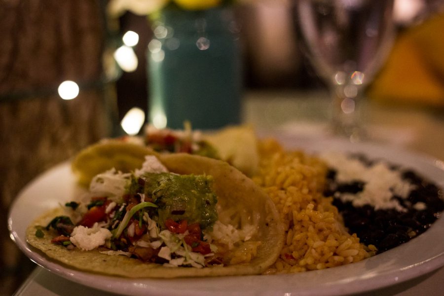 Two chicken tacos topped with iceberg lettuce, cheese, salsa and guacamole lay next to a side of rice and beans at El Paseo Mexican restaurant Sunday Nov. 26, in downtown Santa Barbara. The restaurant is in a great location and the staff was very friendly.