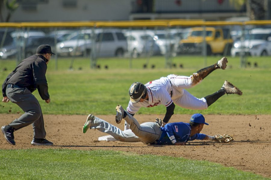 Zack Stockton (No. 12) jumps to second base, while the second basemen from Oxnard College attempts to tag him out on Thursday, March 15, at Pershing Park in Santa Barbara, Calif. Stockton successfully stole second base.