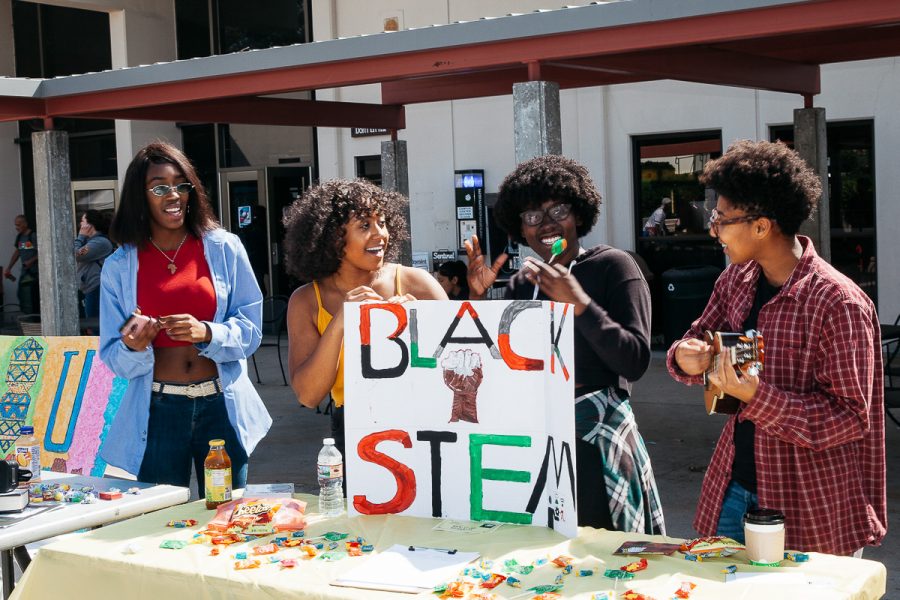 City College student Alexis Willis plays the ukulele while fellow Black Stem Club members Tiffany Love, in black, Jordan Cornett, in yellow, and Naiha Dozier-El, in blue, sing along and dance on club day at the Friendship Plaza at City College in Santa Barbara, Calif., on Wednesday, Sept. 26. “We have a community that we can thrive together and make sure we all feel united,” Love said.
