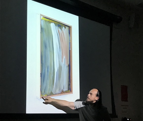 Greg Kozaki explains the details in one of his abstract pieces. Kozaki is a City College art instructor in addition to being abstract artist.