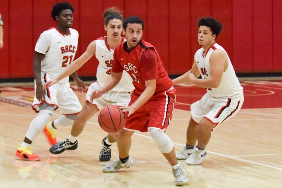 Robert Hutchins (center) alumni from the years 2016 and 2017, looks to pass the ball at the 45th annual alumni basketball game on Thursday, Dec. 6, in the Sports Pavilion gym at City College in Santa Barbara Calif. The current City College team beat the alumni 87-83.