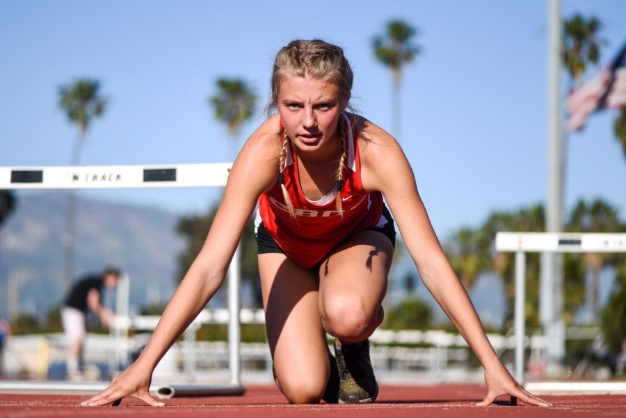 Caroline Smith kneels down, how she would before a race, on Friday, April 12, 2019 at La Playa Stadium at City College in Santa Barbara, Calif.