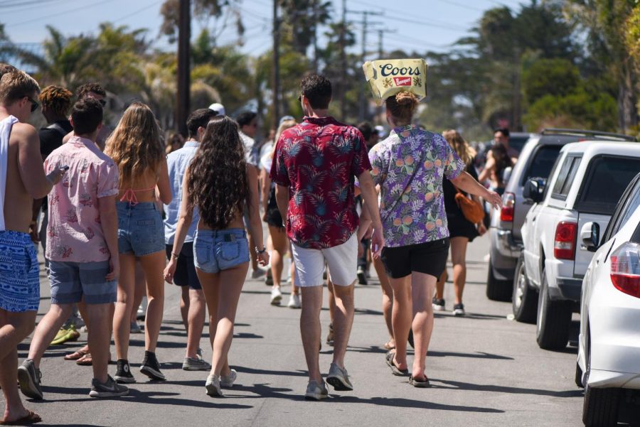 A partier wears an empty Coors beer box as a hat while walking down Del Playa Drive during Del Topia on Saturday, April 7, 2019, in Isla Vista in Santa Barbara, Calif.